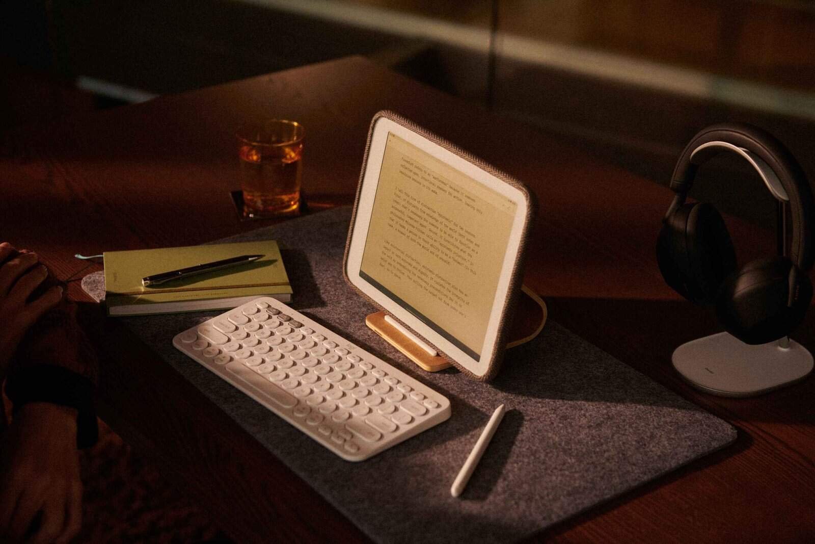 Compact digital workspace setup with tablet, wireless keyboard, headphones, and notepad, ideal for remote work and digital nomads staying at barefoot backpackers hostels.