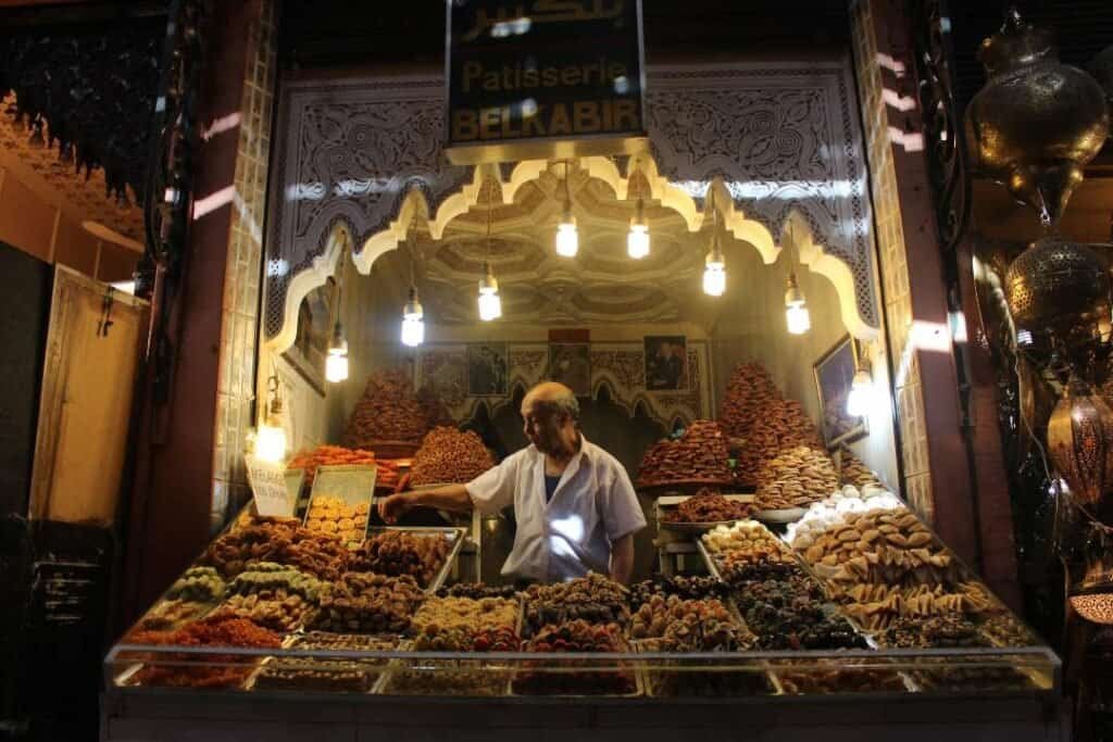 Assorted traditional Moroccan pastries and sweets at a vibrant street market stall in Marrakech.