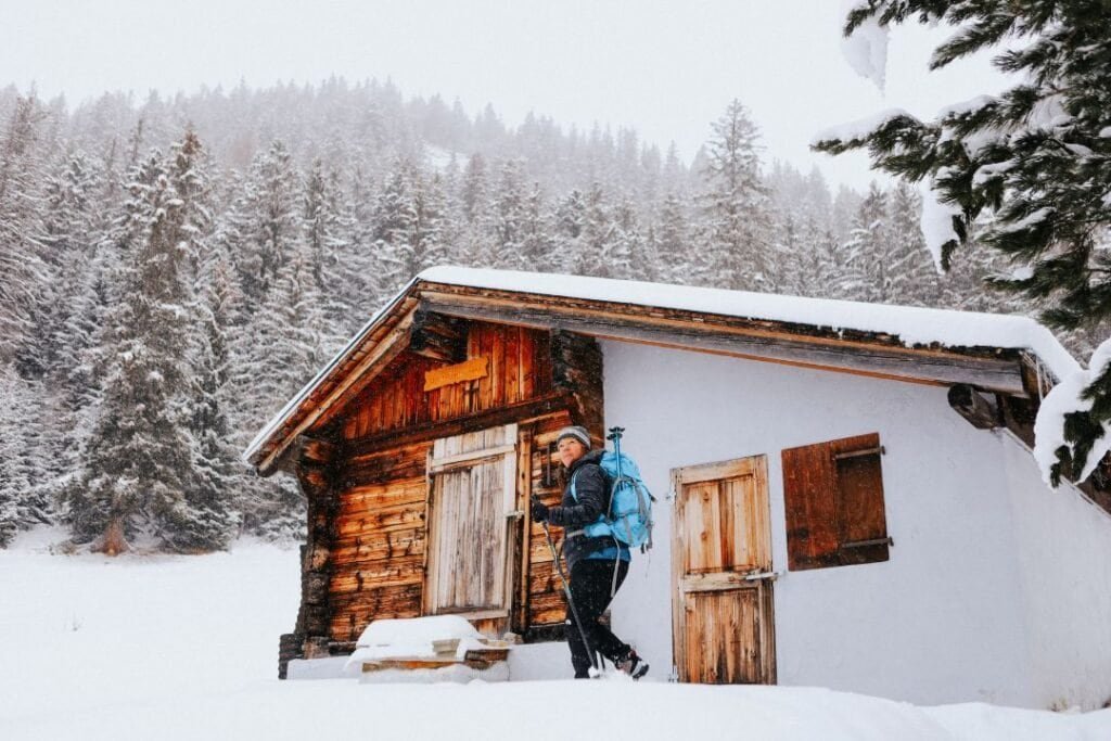 A hiker with a backpack on a snowy winter trail