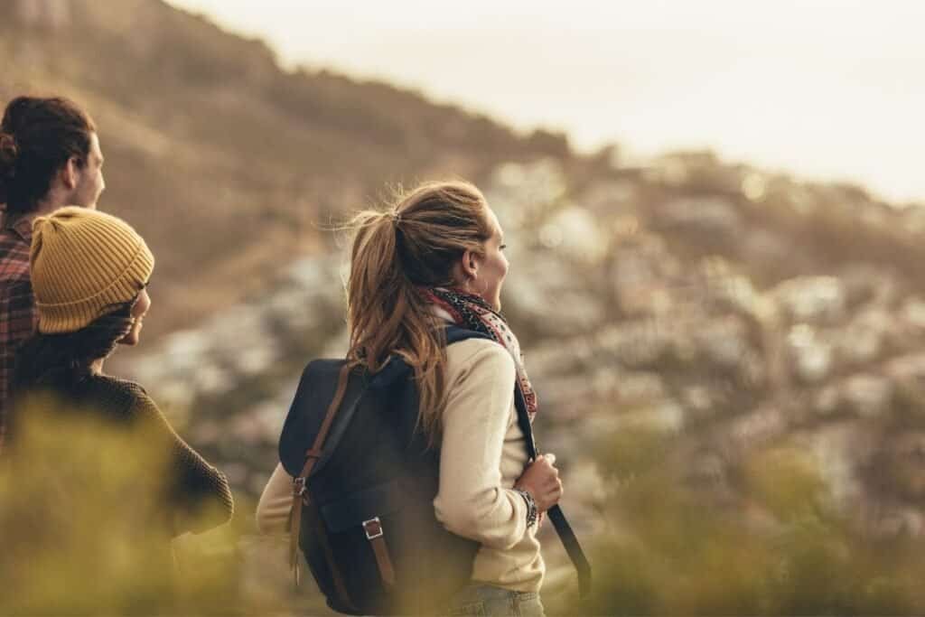 Hiking group enjoying nature, exploring the outdoors in warm layers during golden hour for mindful travel experiences.