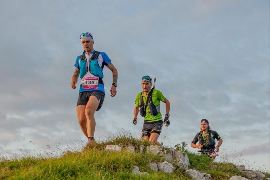 Adventure runners navigating a rocky trail at sunset, embracing mindful outdoor exploration.