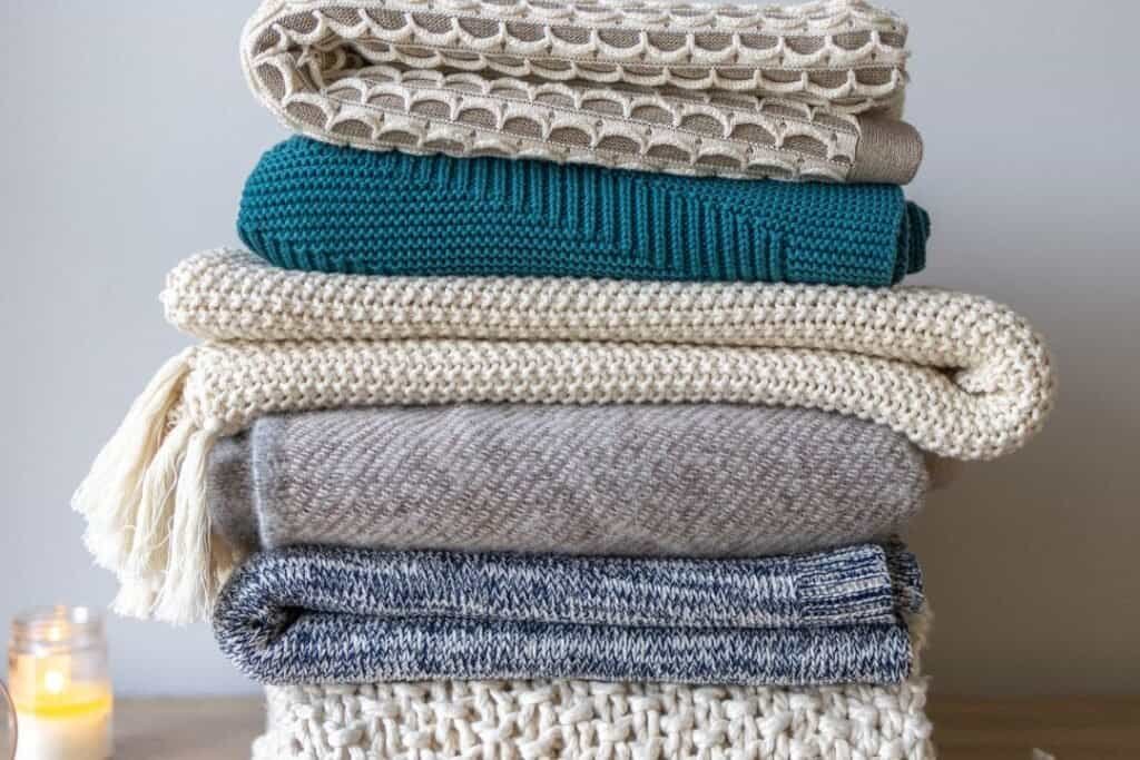 Soft, cozy folded blankets and throws in neutral and calming tones, perfect for sustainable, mindful relaxation at home or on the go.