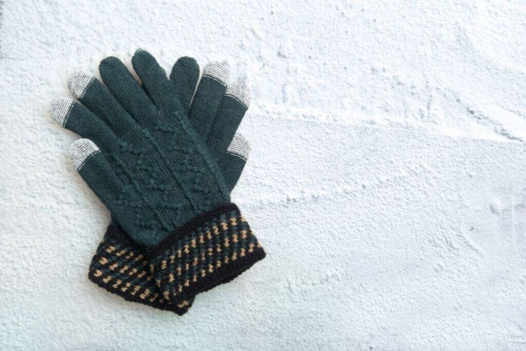 Warm 100% Alpaca Wool gloves on snowy surface, sustainable winter travel gear for grounded exploration and mindful adventures.