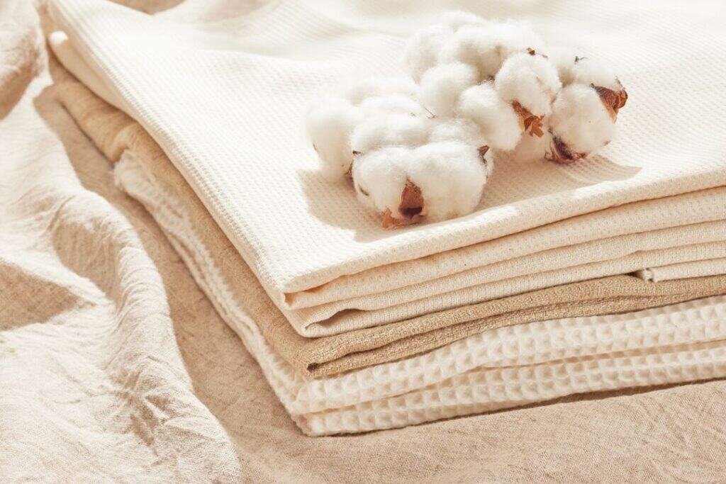 Soft, natural 100% Organic Cotton Blankets arranged in neutral tones, highlighting sustainable textile options for eco-conscious travelers.