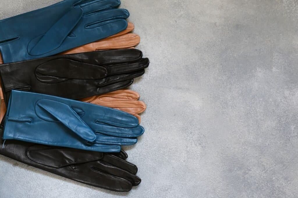 Colorful Cashmere-Lined Leather Gloves arranged on a textured surface, symbolizing mindful travel gear choices.