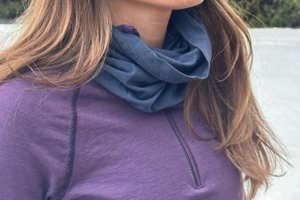 Warm outdoor clothing and neck gaiter for mindful travel in nature's serenity, embracing sustainable adventures with comfort and style.