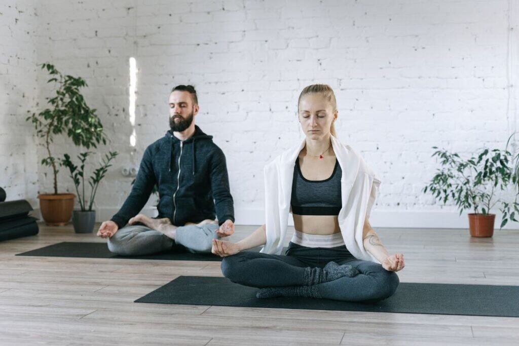Calm meditation practice in a cozy, eco-friendly yoga studio, embracing mindful living and sustainable wellness routines on natural rubber yoga mats.