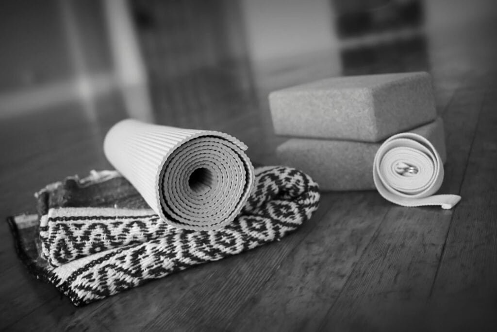 Comfortable yoga mat, foam blocks, and 100% cotton natural yoga blanket for mindful movement and relaxation during sustainable travel.