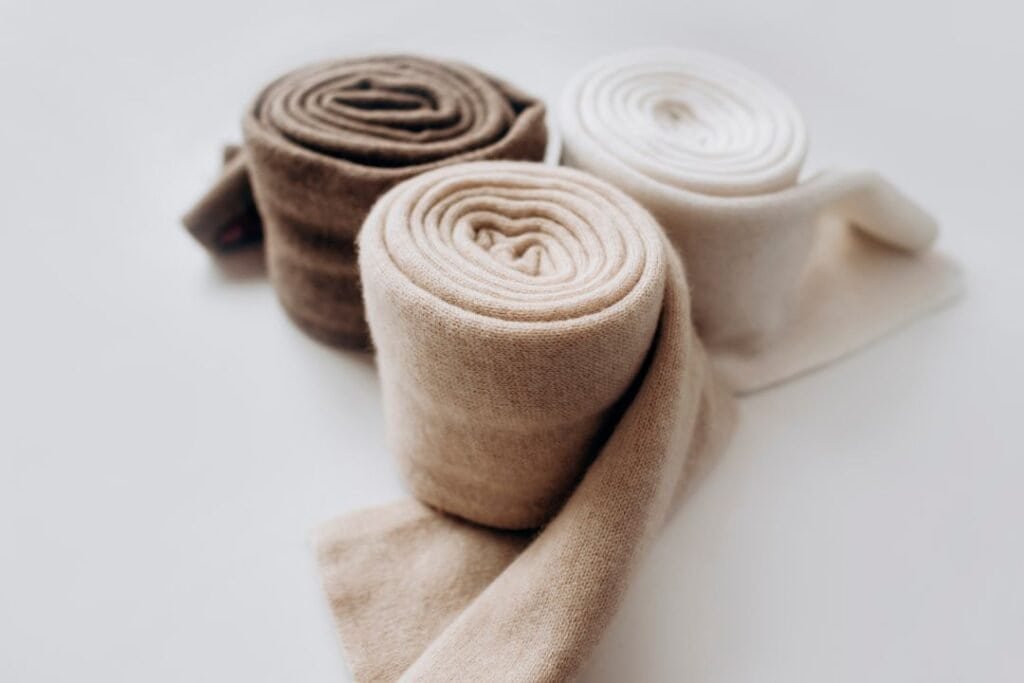 Soft, rolled, natural-colored sustainable socks symbolizing mindful, grounded travel and comfort.