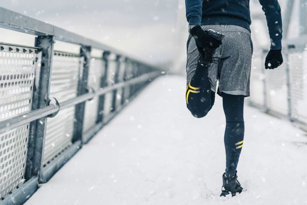 Warm-clad runner with a bag on a snowy bridge, winter outdoor exercise, sustainable active lifestyle, mindful travel in cold climates.