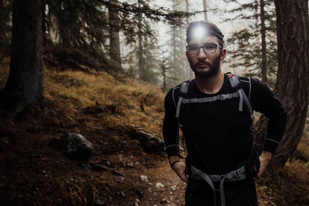 Bright sunlight boosts confidence in hiker walking through a forest trail during outdoor adventure.