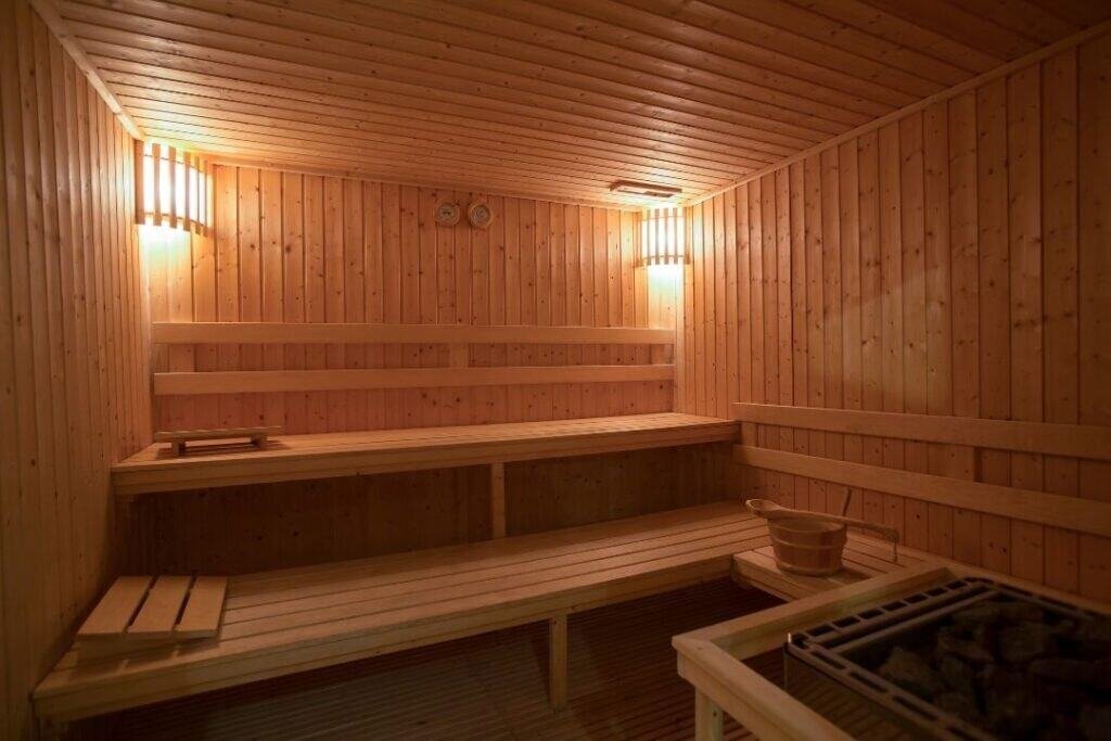 A cozy wooden sauna interior with warm lighting, perfect for sustainable relaxation and mindful wellness experiences.