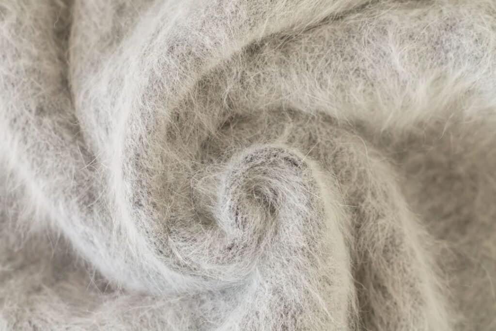 Soft, delicate, natural alpaca wool fiber close-up, showcasing sustainable, eco-friendly materials for mindful living and eco-conscious travel.