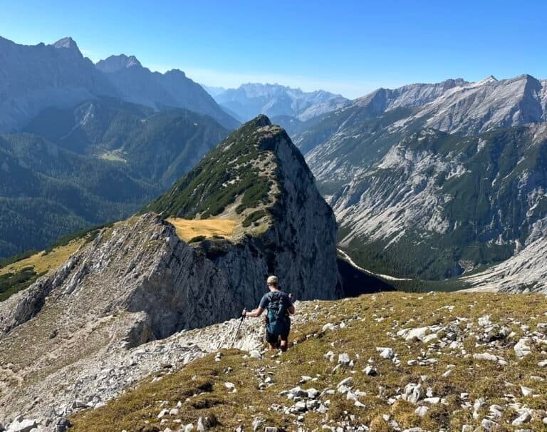 A hiker on a rocky mountain ridge trail