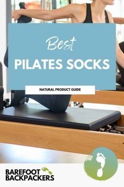 On an exercise mat, a woman stretches her arm in a bright, airy Pilates studio, promoting mindful movement and holistic wellness.